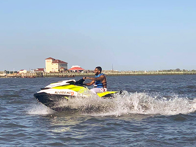 A woman in a life jacket on a personal watercraft